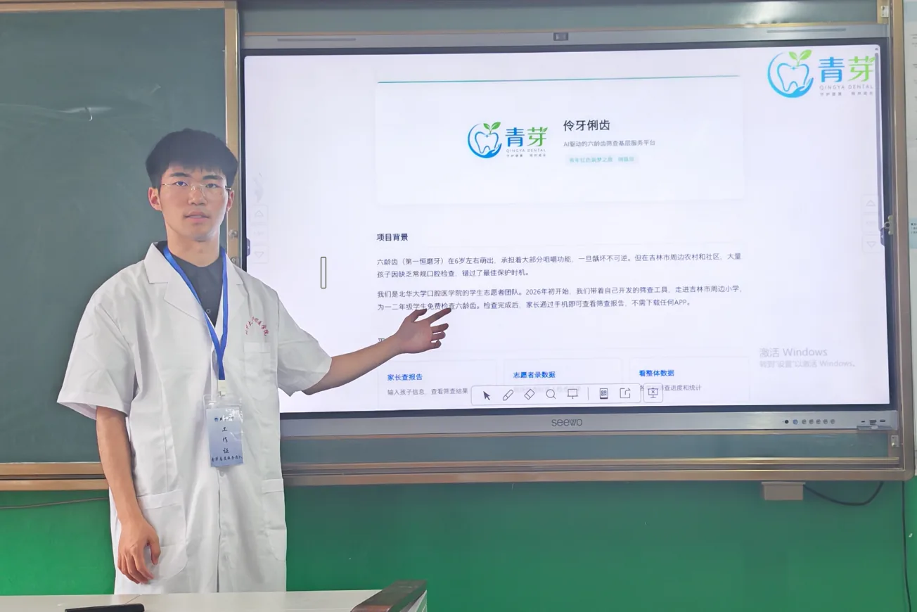 项目负责人身着白大褂在教室用教学一体机向师生介绍伶牙俐齿平台